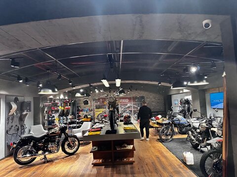 Motosiklet sergileme alanı — yönlendirmeli aydınlatma ızgarası ve teşhir kaideleri
